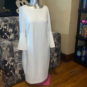 White sheath Calvin Klein dress with 3/4 trumpet sleeves. Knee length dress.